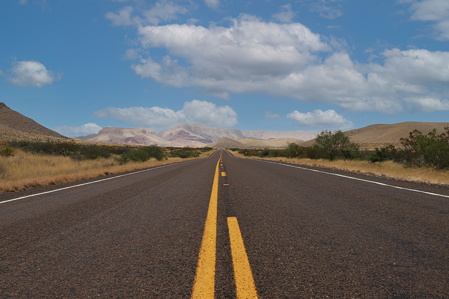 rural highway road with clouds in the horizon
